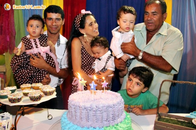 Olinto e Cristiane precisaram da ajuda do vovô para segurar um dos bebes ao apagar as velas do bolo de aniversário. (Foto: Rastro101)